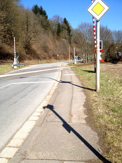 Mittlerweile befinde ich mich auf dem Saarland-Rundweg und stapfe an einer grauen Landstraße entlang